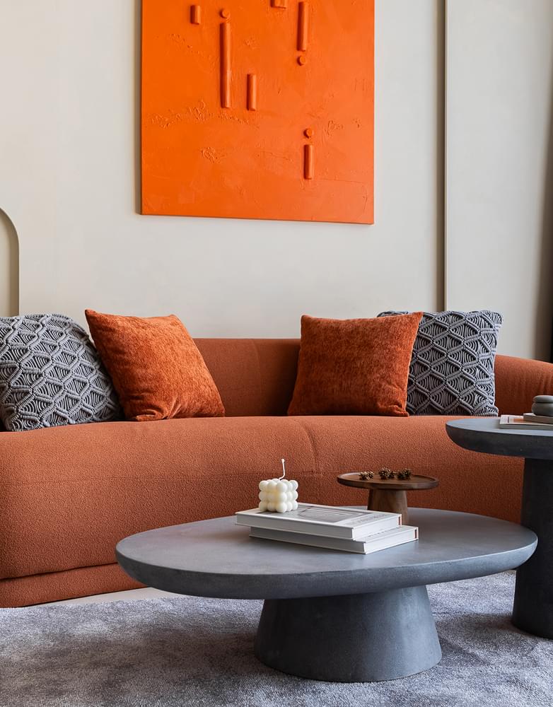 Stylish orange couch with pillows and a coee table, featured in TaskForce's renovation project in Marina Dubai.