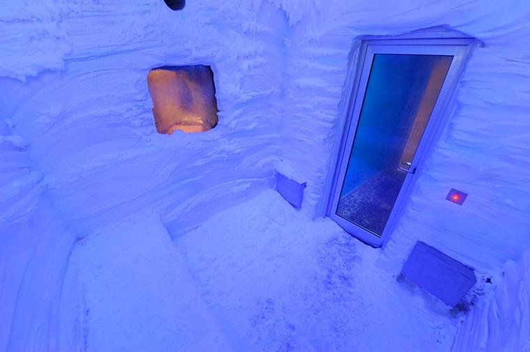 Inside view of an indoor snow room featuring a door, showcasing the icy interior.